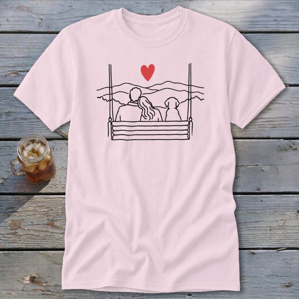Pink t-shirt with line drawing of couple and dog on a swing with heart and mountains.