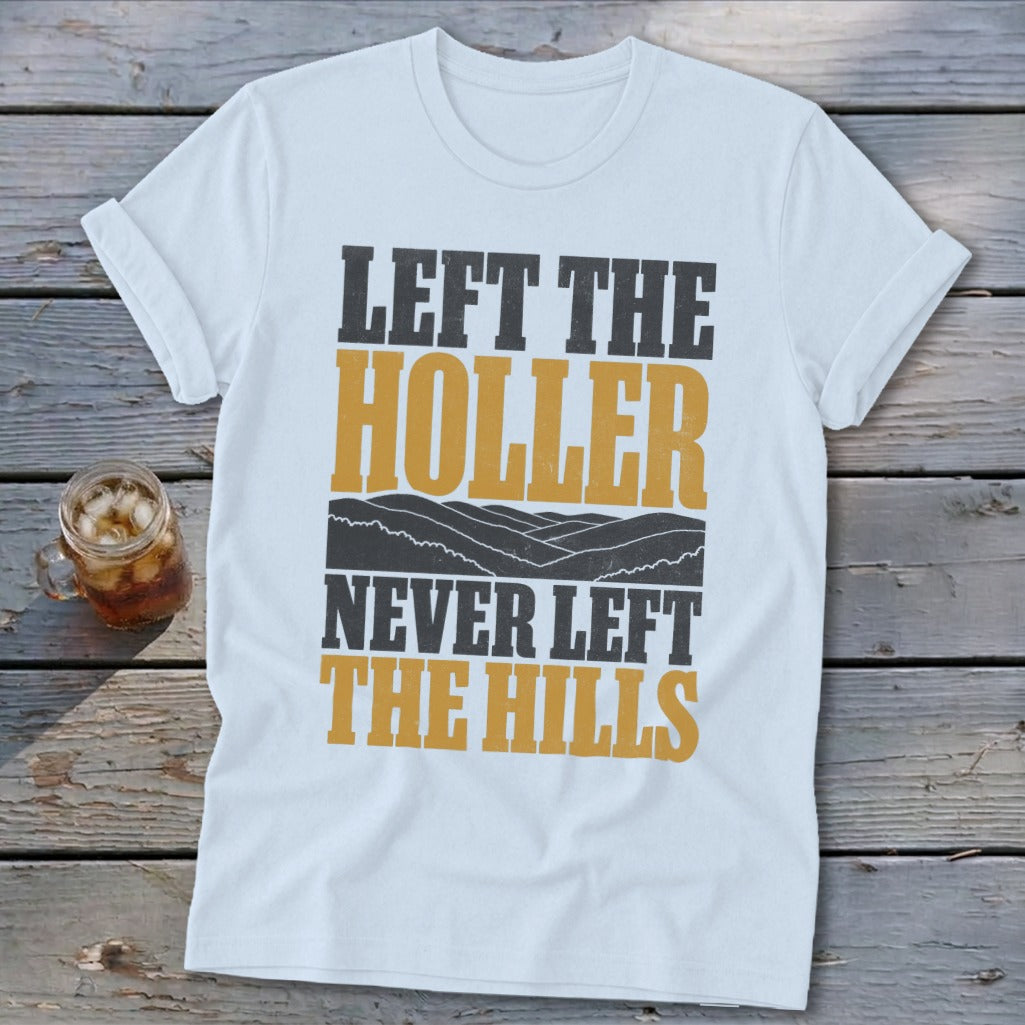 White t-shirt with text "LEFT THE HOLLER NEVER LEFT THE HILLS" and mountain graphic.