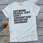 White t-shirt with black text reading "ANMORE PEOPLE JUST DON'T UNDERSTAND MOUNTAIN GRAMMAR."