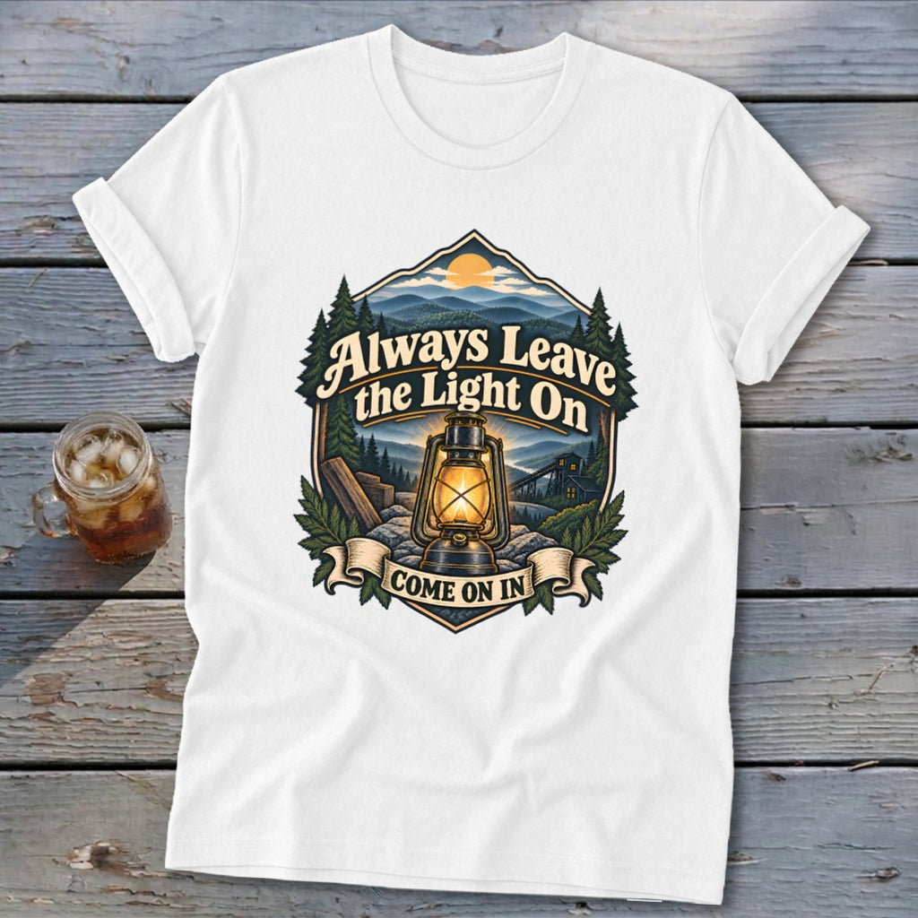White t-shirt with lantern, mountains, and text "Always Leave the Light On, Come On In".