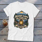 White t-shirt with lantern, mountains, and text "Always Leave the Light On, Come On In".