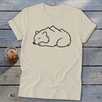 Cream t-shirt with a sleeping bear silhouette overlaid with mountain peaks.