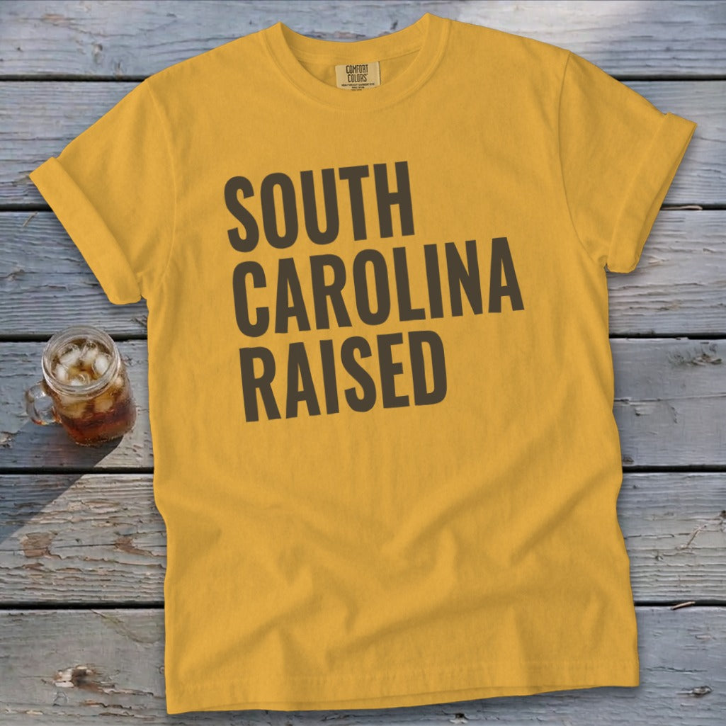 Yellow t-shirt with dark gray text "SOUTH CAROLINA RAISED".