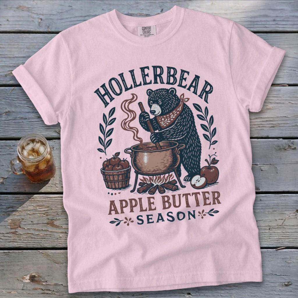 Pink t-shirt with a bear making apple butter, featuring "Hollerbear Apple Butter Season" text.
