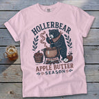 Pink t-shirt with a bear making apple butter, featuring "Hollerbear Apple Butter Season" text.