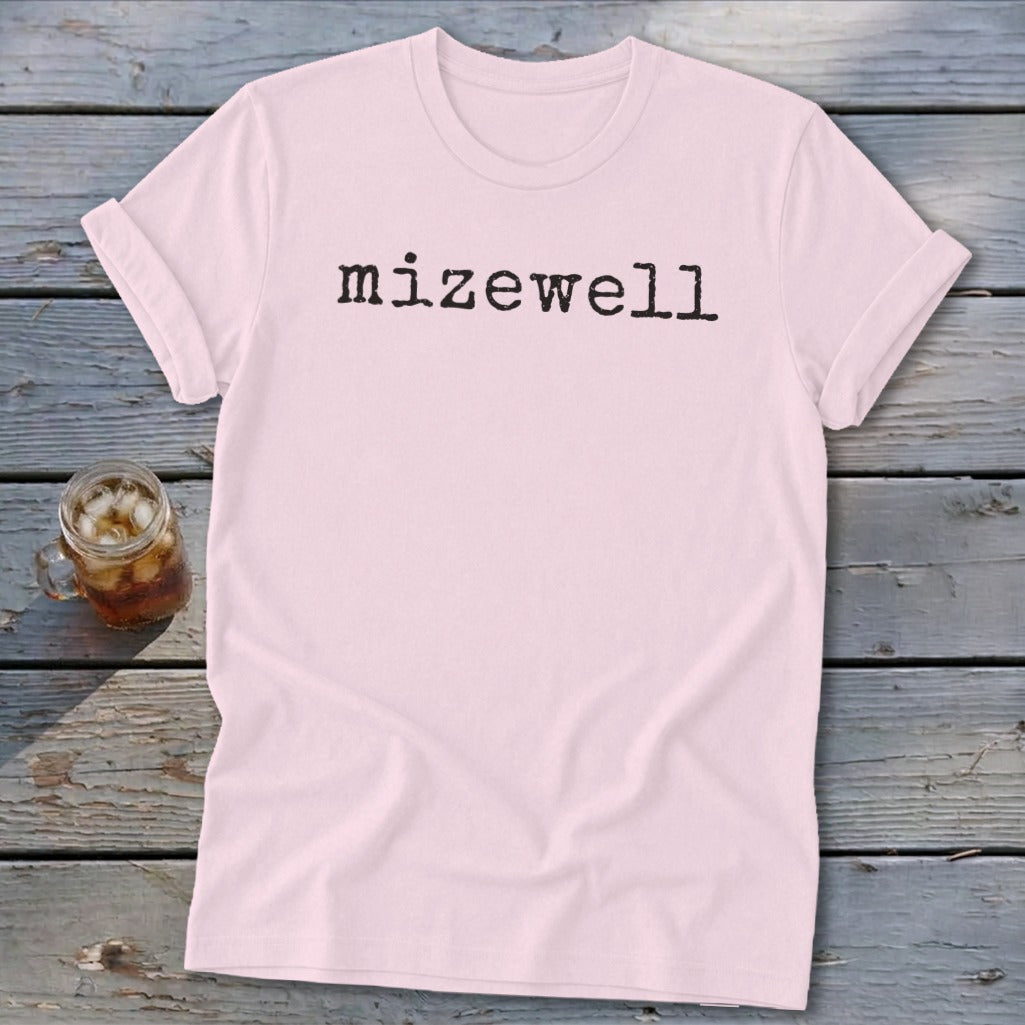 Pink t-shirt with "mizewell" text in black typewriter font.