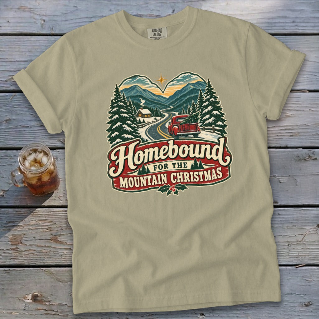 Tan t-shirt with "Homebound for the Mountain Christmas" graphic featuring a snowy scene.