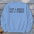 Light blue crewneck sweatshirt with black text that reads "JUST A MESSIN AND A GOMMIN."