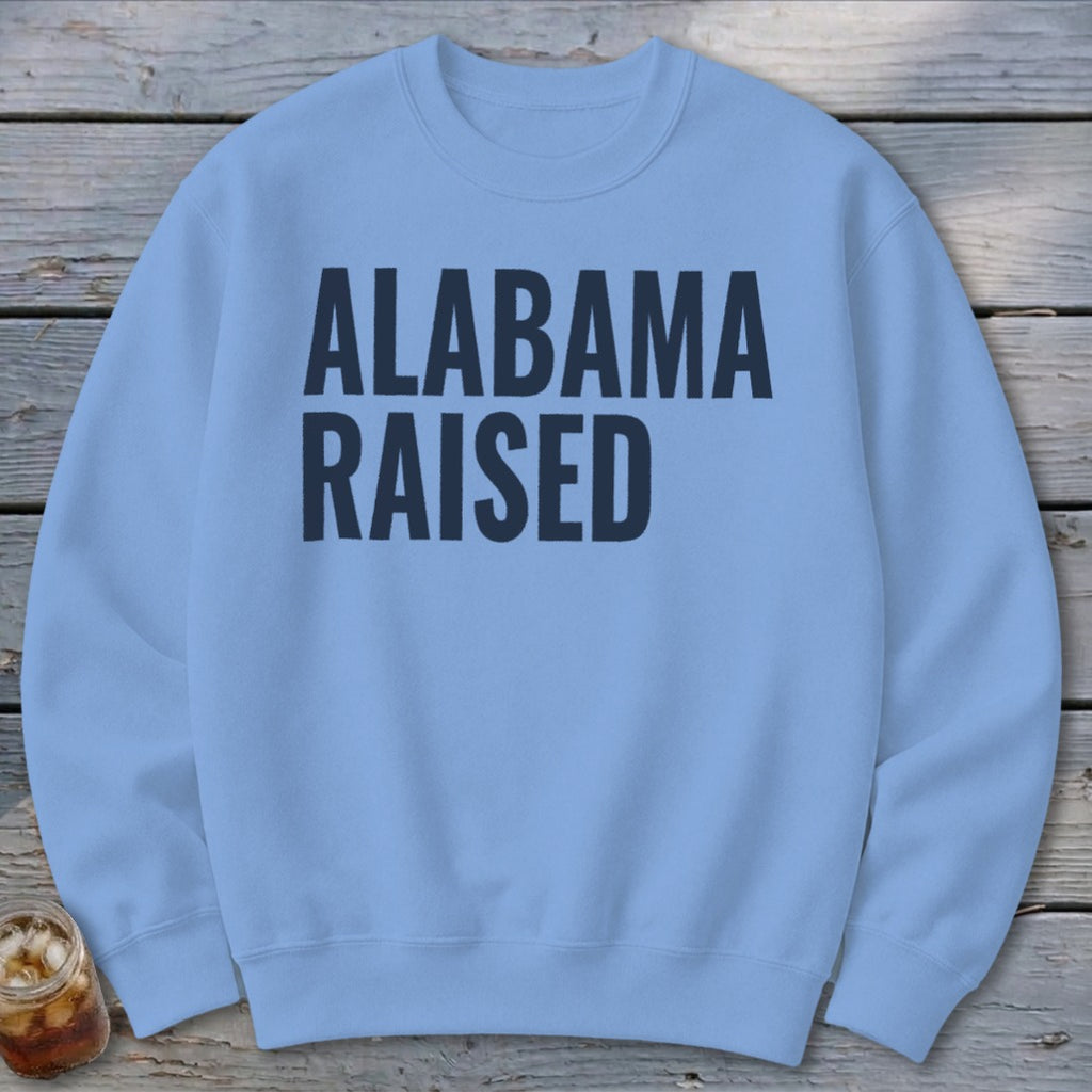 Light blue sweatshirt with "ALABAMA RAISED" printed in dark blue.