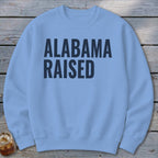 Light blue sweatshirt with "ALABAMA RAISED" printed in dark blue.