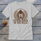 White t-shirt with brown graphic of a lantern and text "ESTABLISHED IN THE HILLS".