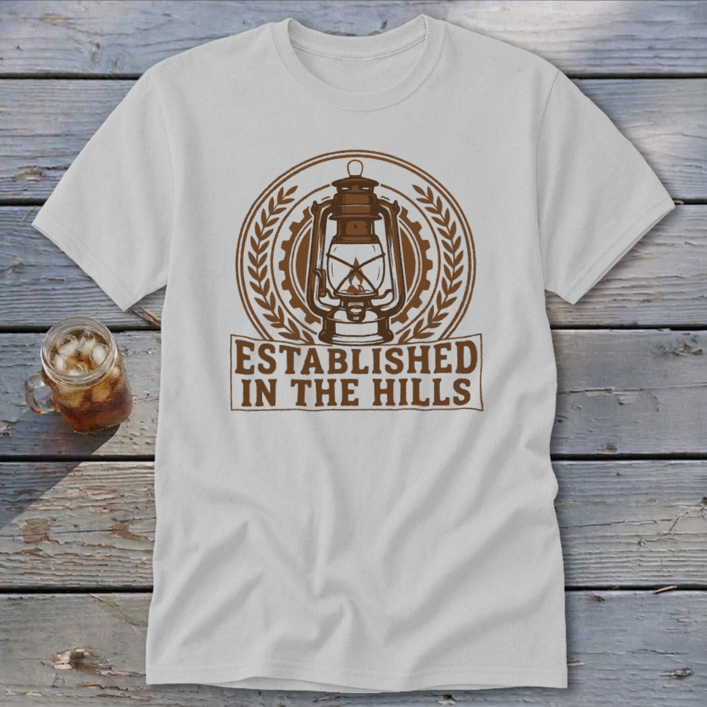White t-shirt with brown graphic of a lantern and text "ESTABLISHED IN THE HILLS".