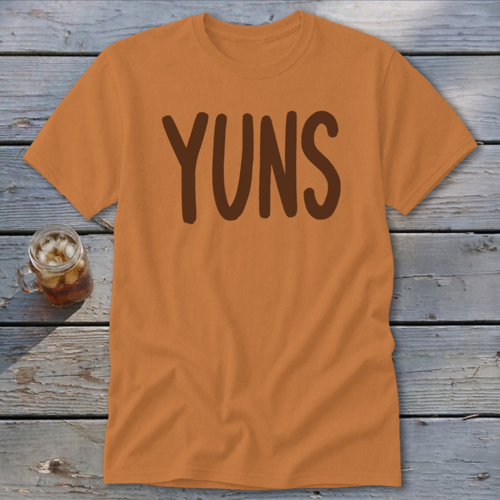 Orange t-shirt with brown text "YUNS" and a glass of iced beverage.