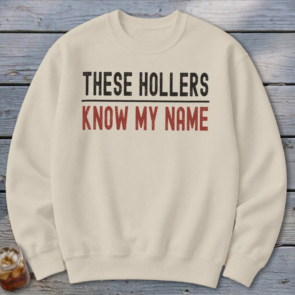 Cream crewneck sweatshirt with "THESE HOLLERS KNOW MY NAME" text.