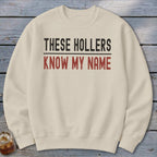 Cream crewneck sweatshirt with "THESE HOLLERS KNOW MY NAME" text.