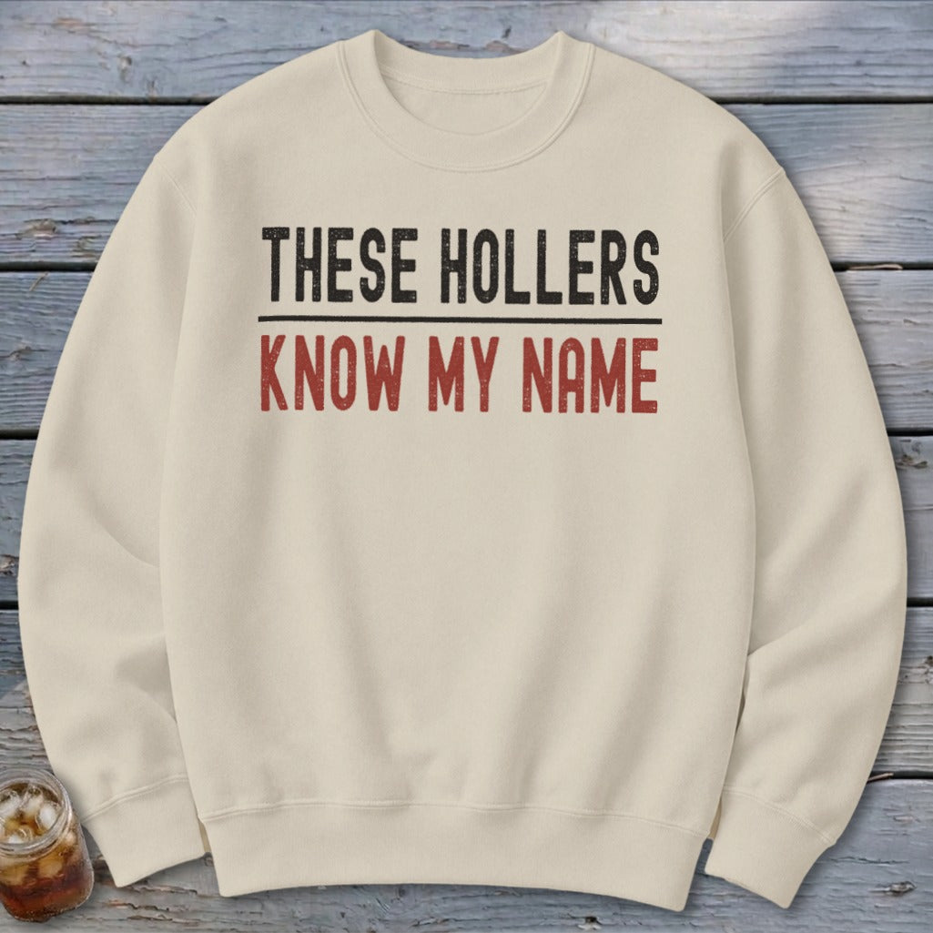 Cream crewneck sweatshirt with "THESE HOLLERS KNOW MY NAME" text.