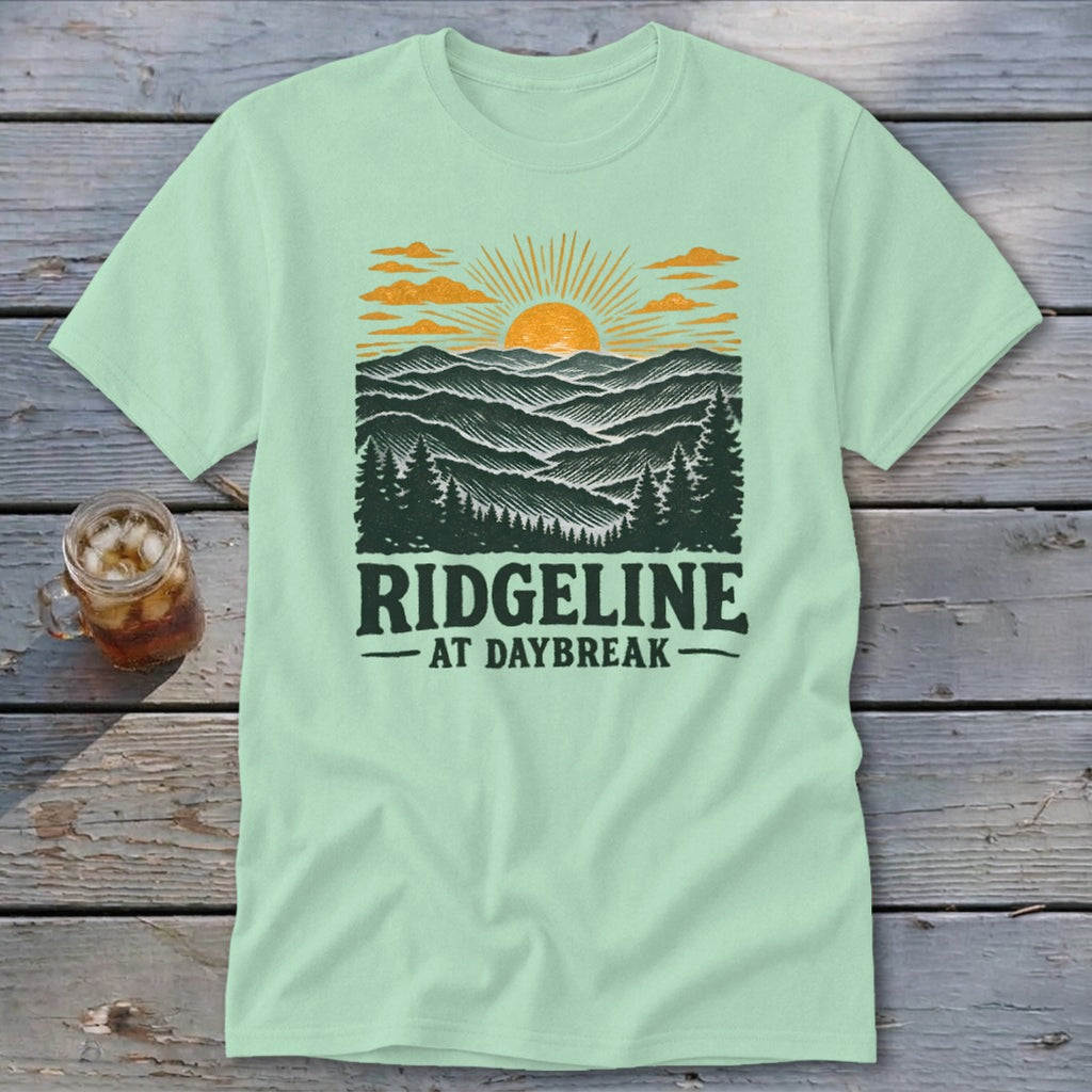 Light green t-shirt with a mountain and sunrise graphic and text "RIDGELINE AT DAYBREAK".