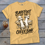 Yellow t-shirt with "Barefoot on the Creek Bank" graphic of bare feet in water.