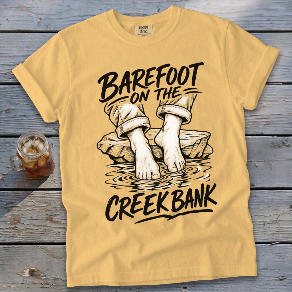 Yellow t-shirt with "Barefoot on the Creek Bank" graphic of bare feet in water.