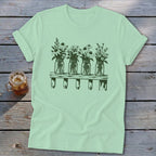 Light green t-shirt featuring a green graphic of four mason jars filled with wildflowers on a shelf.