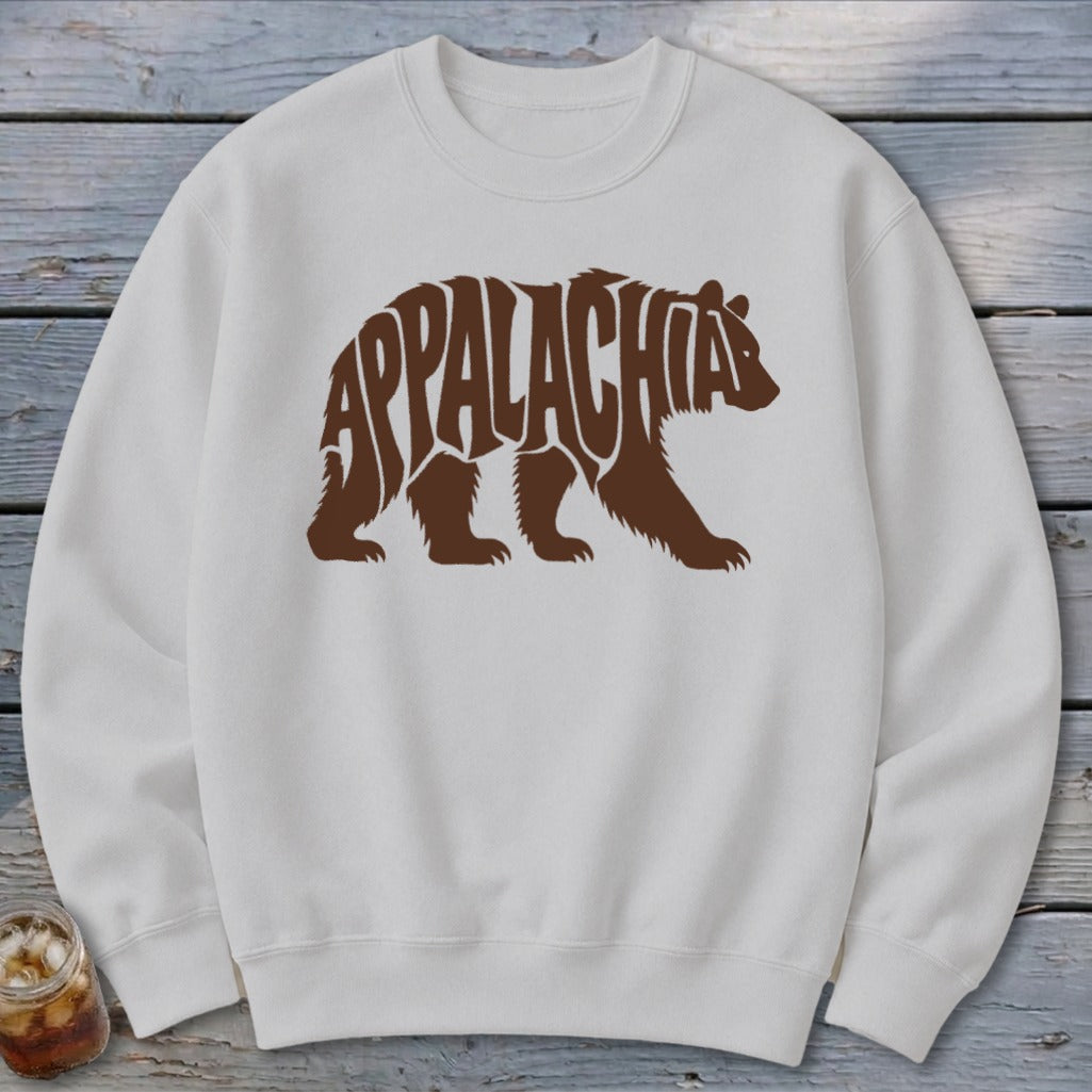 A white crewneck sweatshirt featuring a brown graphic of a walking bear containing the word Appalachia.
