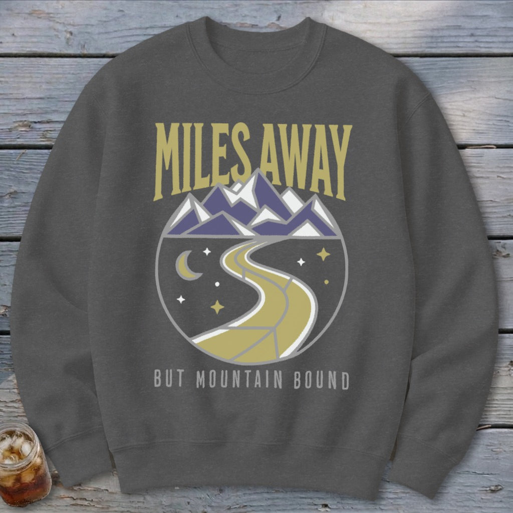 Dark gray sweatshirt with "Miles Away But Mountain Bound" text and mountain/road graphic.