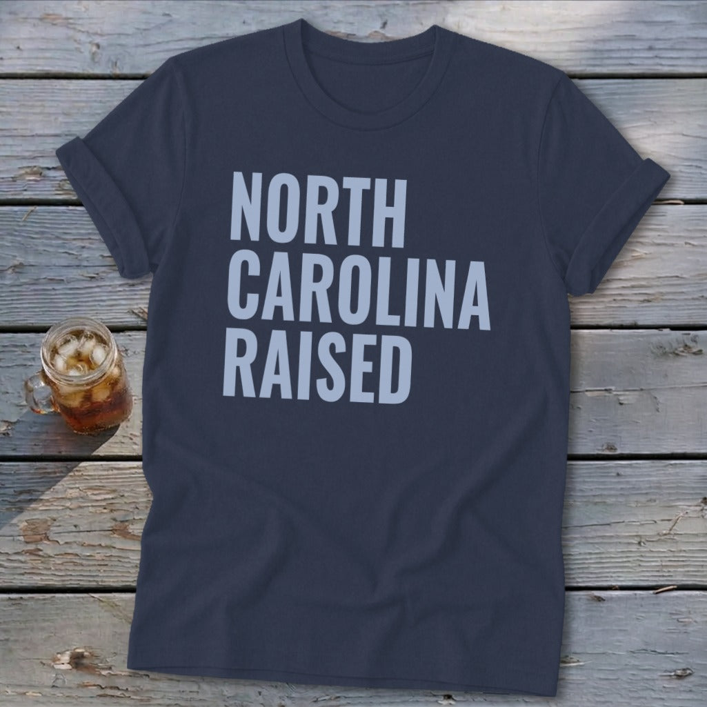 Navy t-shirt with "NORTH CAROLINA RAISED" in light blue text.