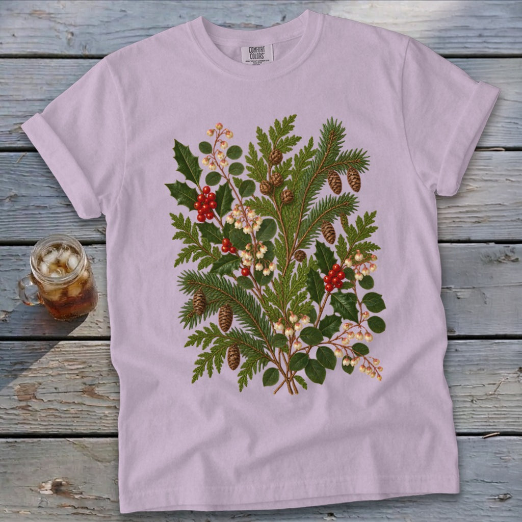 Light purple t-shirt with a vintage botanical print of holly, pine branches, berries, and pinecones.
