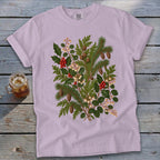 Light purple t-shirt with a vintage botanical print of holly, pine branches, berries, and pinecones.