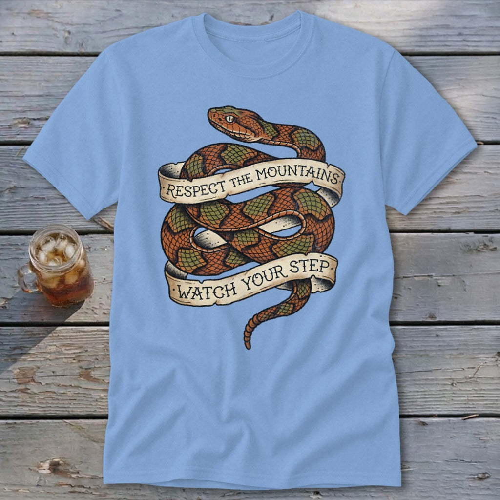 Light blue t-shirt featuring a coiled snake with banners reading "Respect the Mountains" and "Watch Your Step".