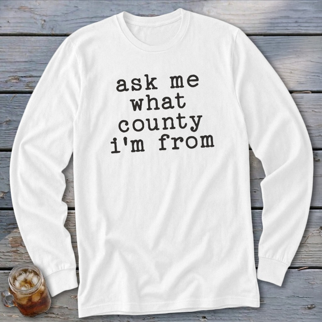 White long sleeve t-shirt with black text reading "ask me what county i'm from".
