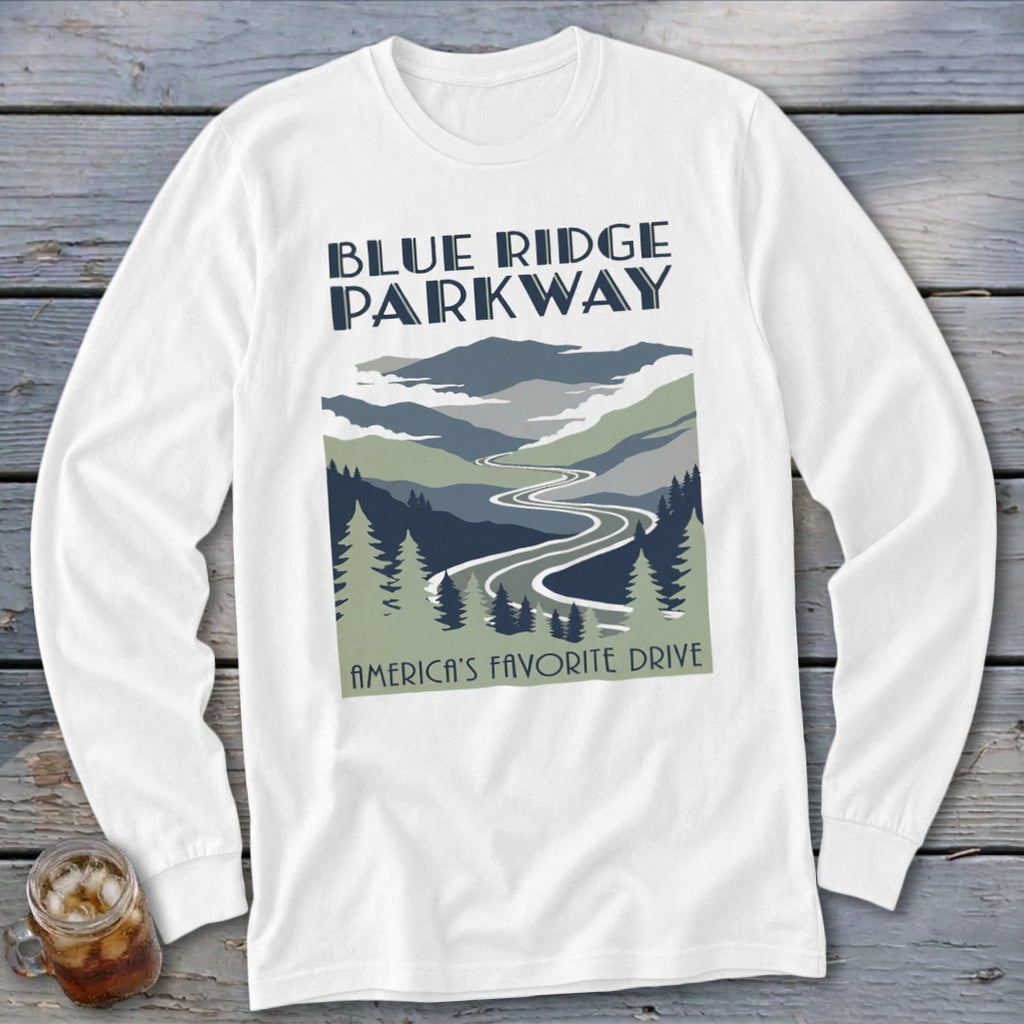 A white long-sleeved t-shirt featuring a Blue Ridge Parkway graphic with mountains, a winding road, and evergreen trees.