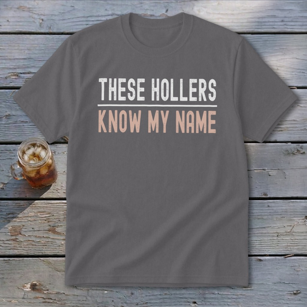 Gray t-shirt with white and pink text that reads "THESE HOLLERS KNOW MY NAME".