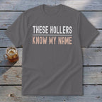 Gray t-shirt with white and pink text that reads "THESE HOLLERS KNOW MY NAME".