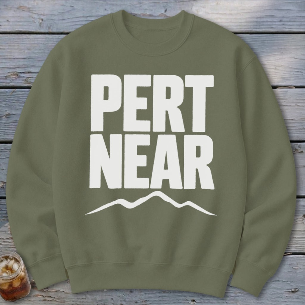 Olive green crewneck sweatshirt featuring white block text reading PERT NEAR above a mountain outline.