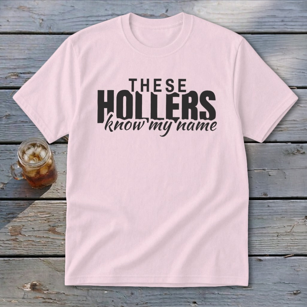 Pink t-shirt with black text "THESE HOLLERS know my name" and a glass of iced tea.