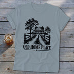 Light blue t-shirt with a black graphic of a house, trees, and fence, saying "OLD HOME PLACE".