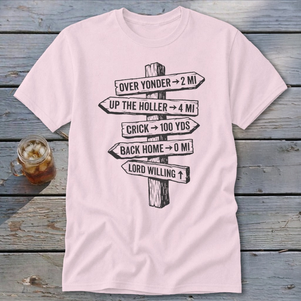 A light pink t-shirt featuring a black graphic of a rustic wooden signpost with directional distance text.