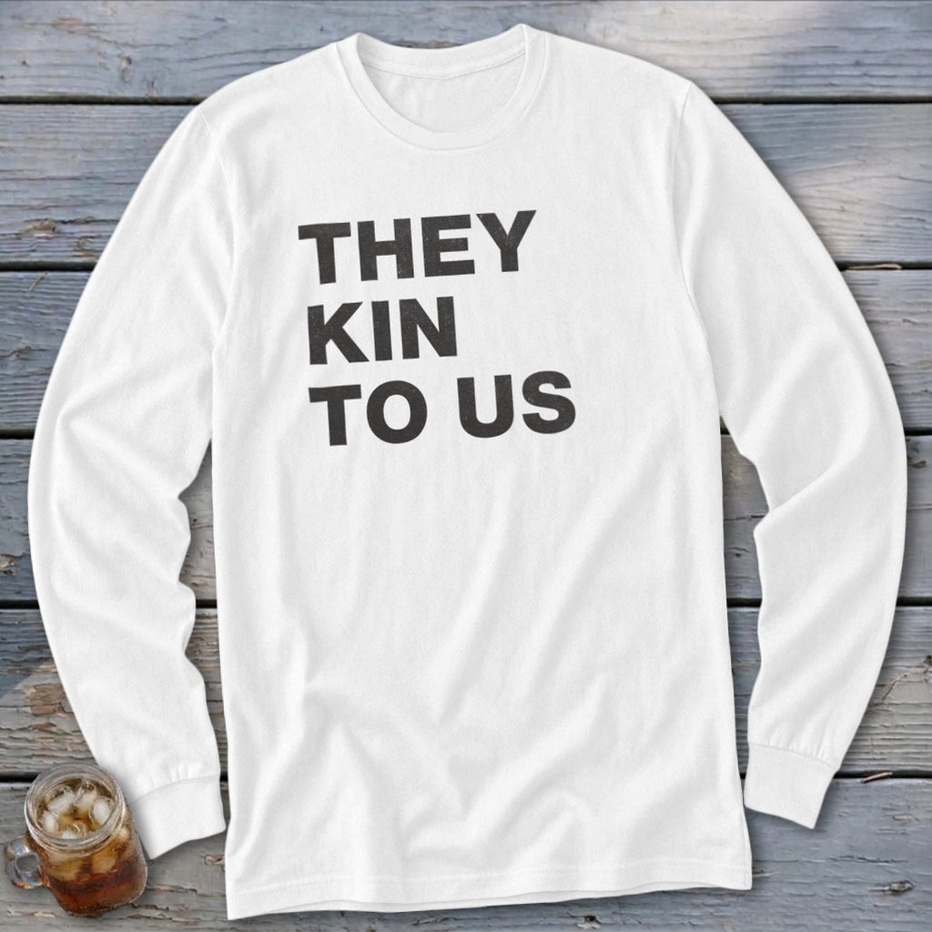 White long-sleeve shirt with black text that reads "THEY KIN TO US"