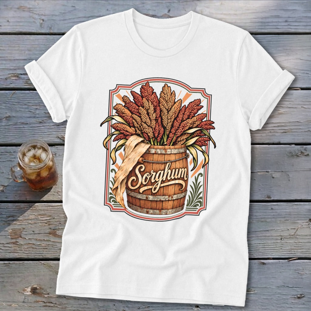 White t-shirt with sorghum stalks in a wooden barrel, featuring the word "Sorghum".