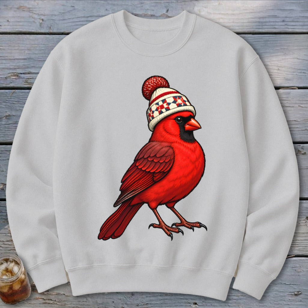 A grey crewneck sweatshirt featuring a graphic of a bright red cardinal wearing a winter beanie.