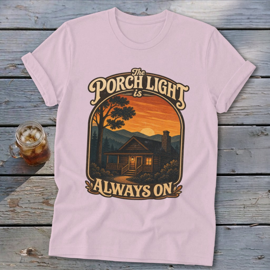 Pink t-shirt with "The Porch Light is Always On" text and cabin scene graphic.