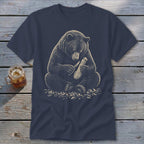 Bear carving wood with a knife on a navy t-shirt.