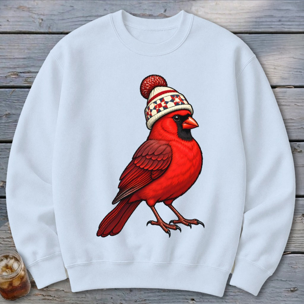 A white crewneck sweatshirt featuring a graphic of a red cardinal wearing a winter beanie.