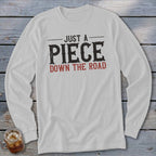 White long-sleeve t-shirt with "Just a Piece Down the Road" text.