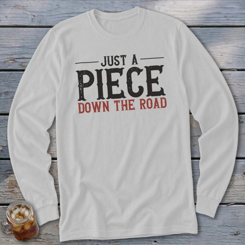White long-sleeve t-shirt with "Just a Piece Down the Road" text.