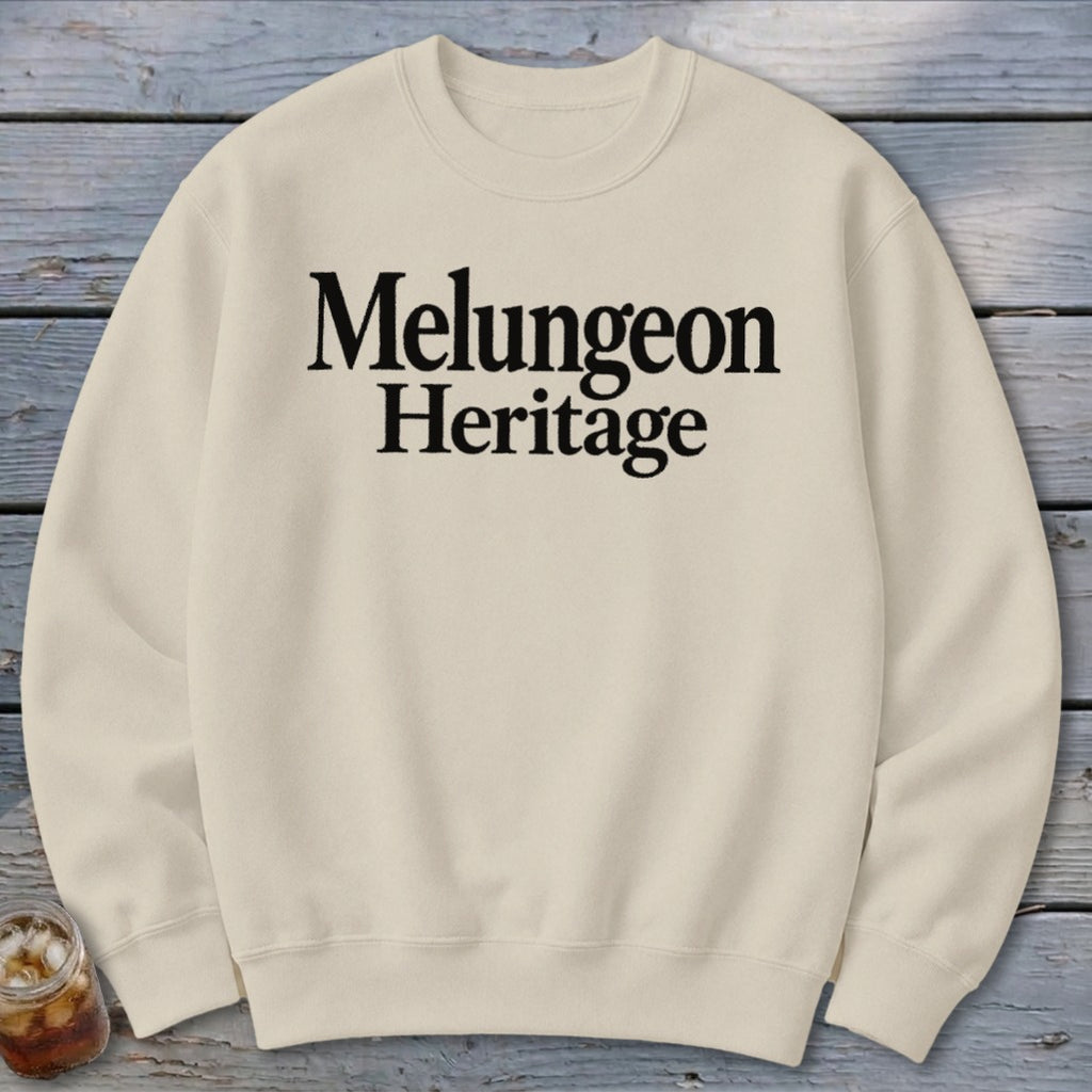 A cream crewneck sweatshirt featuring the black text Melungeon Heritage centered on the chest.