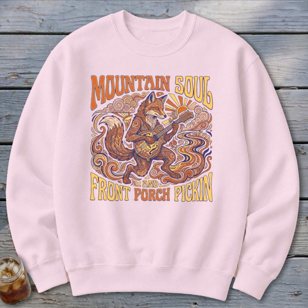 Light pink sweatshirt with a fox playing guitar and text "Mountain Soul and Front Porch Pickin".