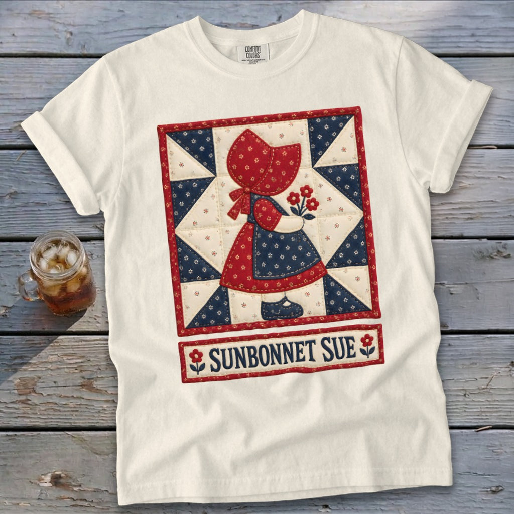 Cream t-shirt with "Sunbonnet Sue" graphic of a girl in a quilt block pattern.