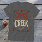 Grey t-shirt with distressed sign graphic: "CRICK" crossed out, "CREEK" with checkmark.